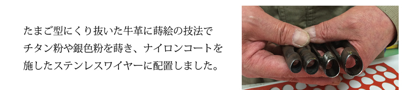 たまご型にくり抜いた牛革に蒔絵の技法で
チタン粉や銀色粉を蒔き、ナイロンコートを
施したステンレスワイヤーに配置しました。